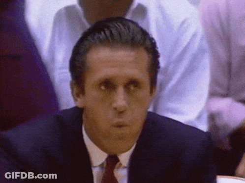 A Man In A Suit And Tie Looks At Something GIF