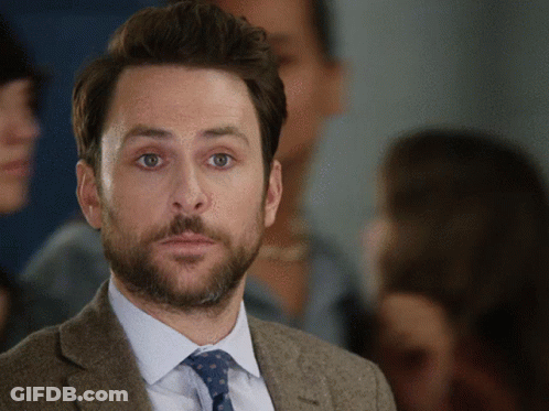 A Man In A Suit And Tie Looks At The Camera GIF