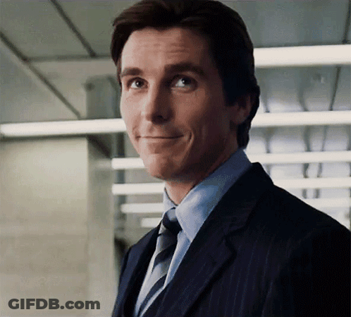 A Man In A Suit And Tie Looks At The Camera GIF