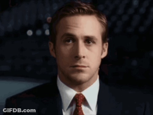 A Man In A Suit And Tie Looks At The Camera With A Serious Look On His Face GIF