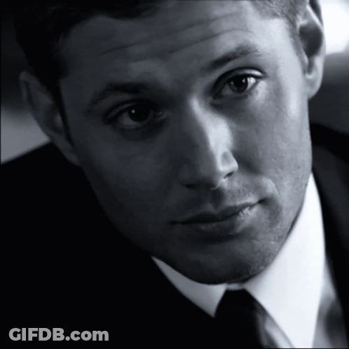 A Man In A Suit And Tie Looks At The Camera With A Serious Look On His Face GIF