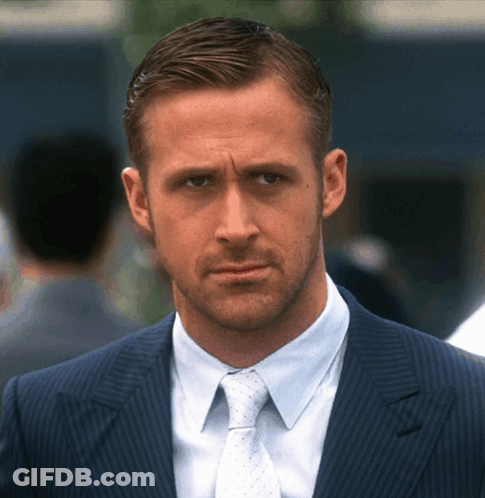 A Man In A Suit And Tie Looks At The Camera With A Serious Look On His Face GIF