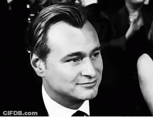 A Man In A Suit And Tie Looks At The Camera GIF