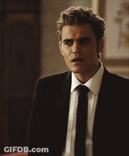 A Man In A Suit And Tie Looks To His Left GIF