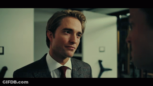 A Man In A Suit And Tie Looks To The Side GIF