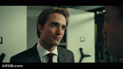 A Man In A Suit And Tie Looks To The Side GIF