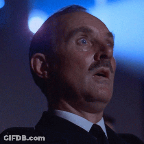 A Man In A Suit And Tie Looks Up At Something GIF