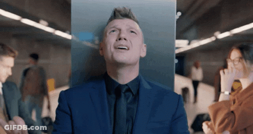 A Man In A Suit And Tie Looks Up At Something GIF