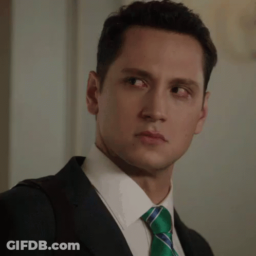 A Man In A Suit And Tie Making A Face GIF