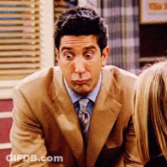 A Man In A Suit And Tie Making A Face GIF