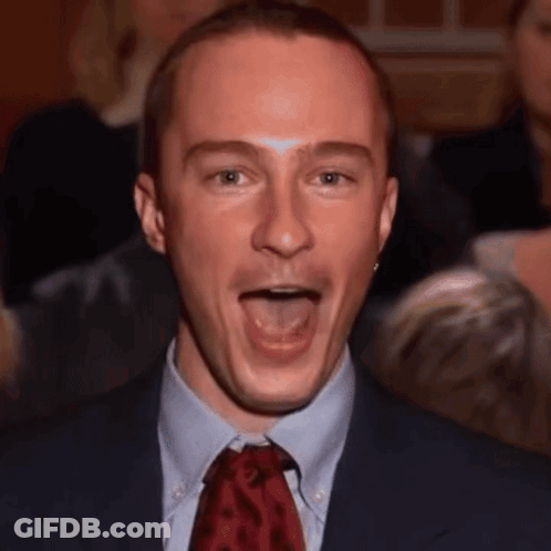 A Man In A Suit And Tie Making A Funny Face GIF