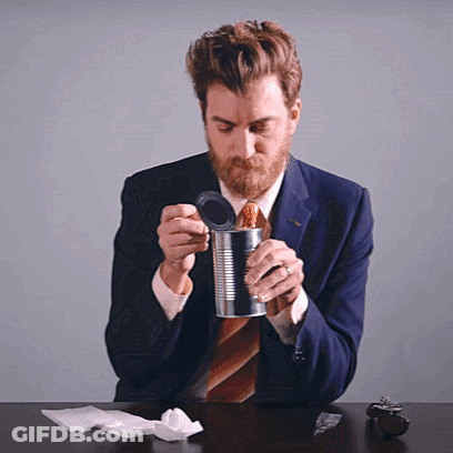 A Man In A Suit And Tie Opens A Can GIF