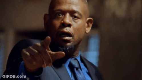 A Man In A Suit And Tie Points His Finger At The Camera GIF