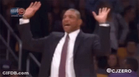 A Man In A Suit And Tie Raising His Arms In The Air GIF