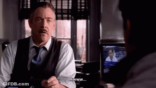 A Man In A Suit And Tie Says Awww In Front Of Another Man GIF