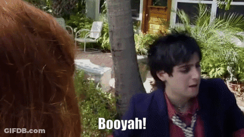A Man In A Suit And Tie Says Booyah While Standing Next To A Woman GIF
