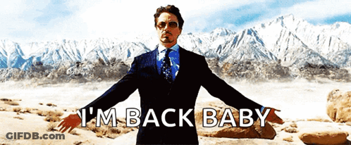A Man In A Suit And Tie Says I 'M Back Baby With His Arms Outstretched GIF