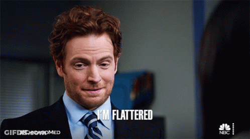 A Man In A Suit And Tie Says " I 'M Flattered " On The Screen GIF