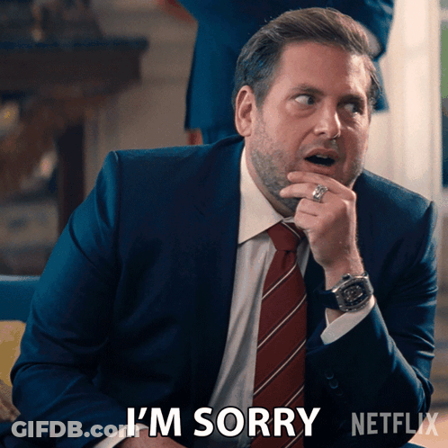A Man In A Suit And Tie Says I 'M Sorry In A Netflix Ad GIF