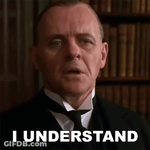 A Man In A Suit And Tie Says I Understand In Front Of A Bookshelf . GIF