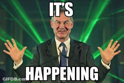 A Man In A Suit And Tie Says It 'S Happening In Front Of A Green Light GIF