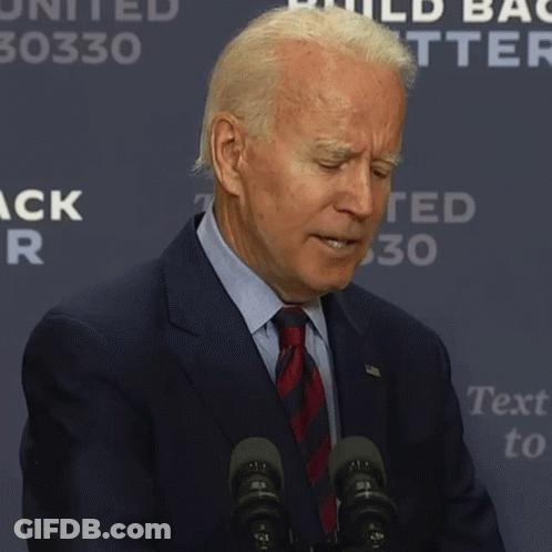 A Man In A Suit And Tie Says It 'S Hard While Standing In Front Of Microphones GIF