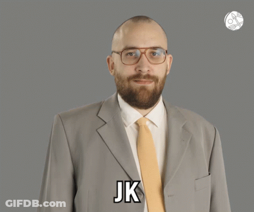 A Man In A Suit And Tie Says Jk On His Chest GIF