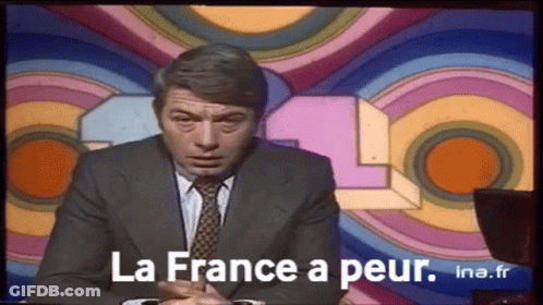 A Man In A Suit And Tie Says La France A Peur On A Screen GIF