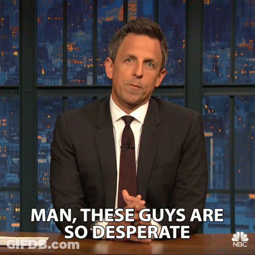 A Man In A Suit And Tie Says " Man These Guys Are So Desperate " While Sitting At A Desk GIF