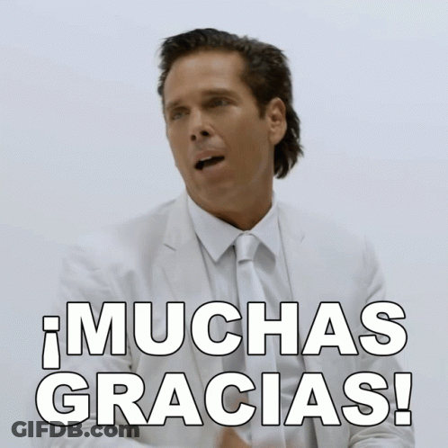 A Man In A Suit And Tie Says Muchas Gracias In Spanish GIF