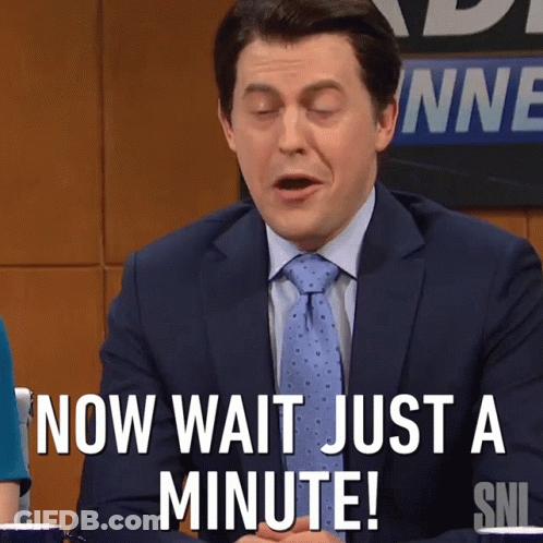 A Man In A Suit And Tie Says " Now Wait Just A Minute ! " GIF