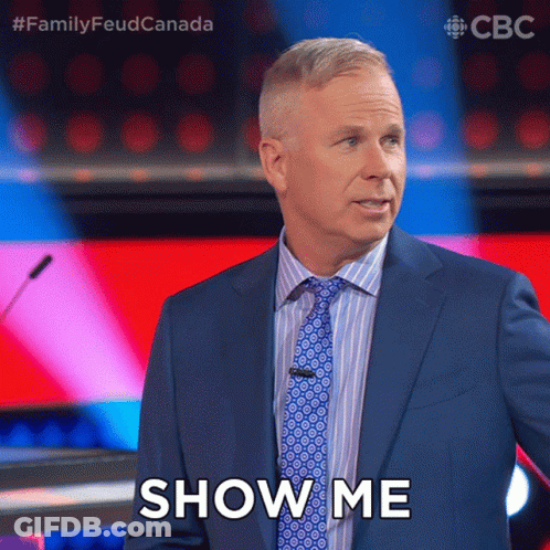 A Man In A Suit And Tie Says Show Me In Front Of A Microphone GIF