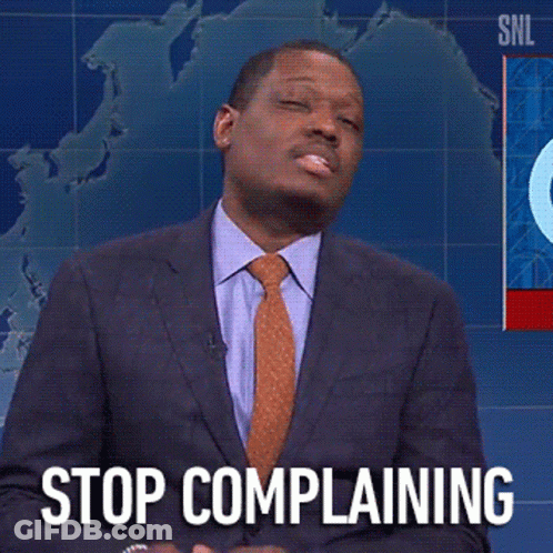 A Man In A Suit And Tie Says " Stop Complaining " In Front Of A Map Of The World GIF
