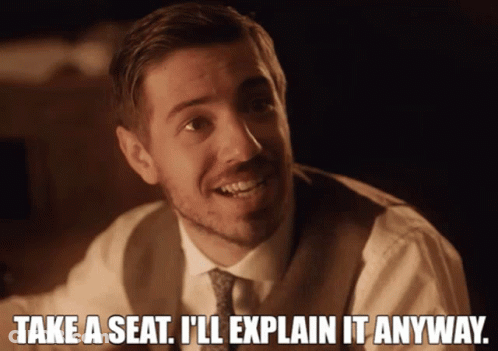A Man In A Suit And Tie Says Take A Seat GIF