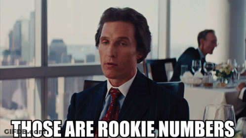 A Man In A Suit And Tie Says " Those Are Rookie Numbers " In Front Of A Window GIF