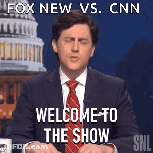 A Man In A Suit And Tie Says Welcome To The Show In Front Of The Cnn Building GIF