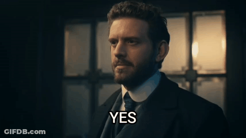 A Man In A Suit And Tie Says Yes In Front Of A Window GIF