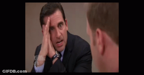 A Man In A Suit And Tie Scratches His Head GIF