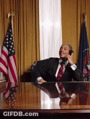 Man In Suit And Tie Talking On Phone At Desk GIF