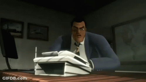 A Man In A Suit And Tie Sits At A Desk With A Stack Of Papers On It GIF