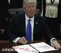 A Man In A Suit And Tie Sits At A Table Signing A Document That Says Tunisia GIF