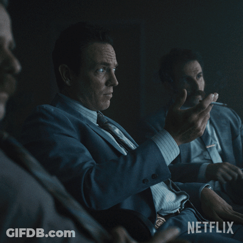 A Man In A Suit And Tie Sits In A Dark Room With The Words " It 'S A Fair Point " On The Bottom GIF