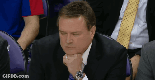 A Man In A Suit And Tie Sits In A Purple Chair GIF