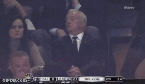 A Man In A Suit And Tie Sits In The Stands Watching A Game Between Dallas And Nyg GIF