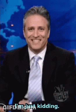 A Man In A Suit And Tie Smiles And Says I 'M Just Kidding GIF
