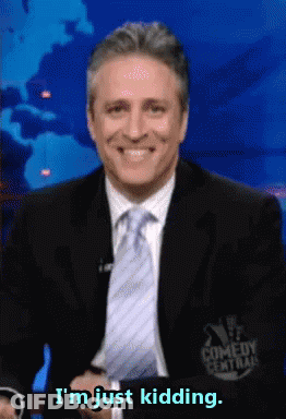A Man In A Suit And Tie Smiles And Says I 'M Just Kidding GIF