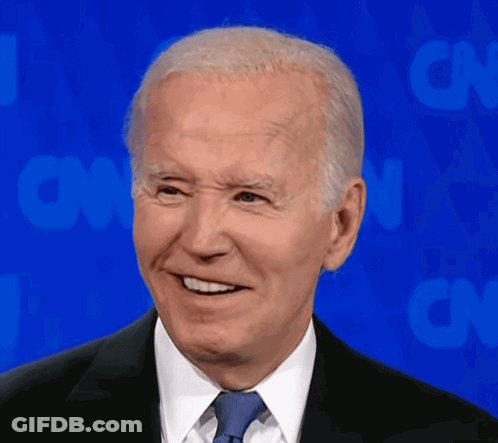 A Man In A Suit And Tie Smiles In Front Of Cnn GIF