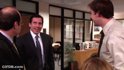 A Man In A Suit And Tie Smiles While Talking To Another Man GIF
