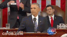 A Man In A Suit And Tie Stands At A Podium With A Sign That Says Live On It GIF