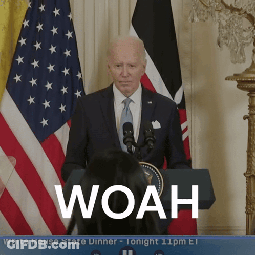 A Man In A Suit And Tie Stands At A Podium With The Word Woah On The Screen GIF
